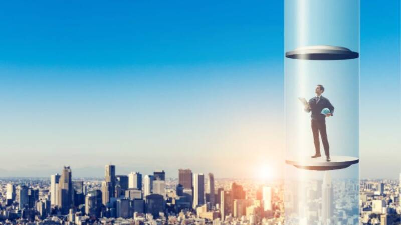 Businessman in elevator rising above the city