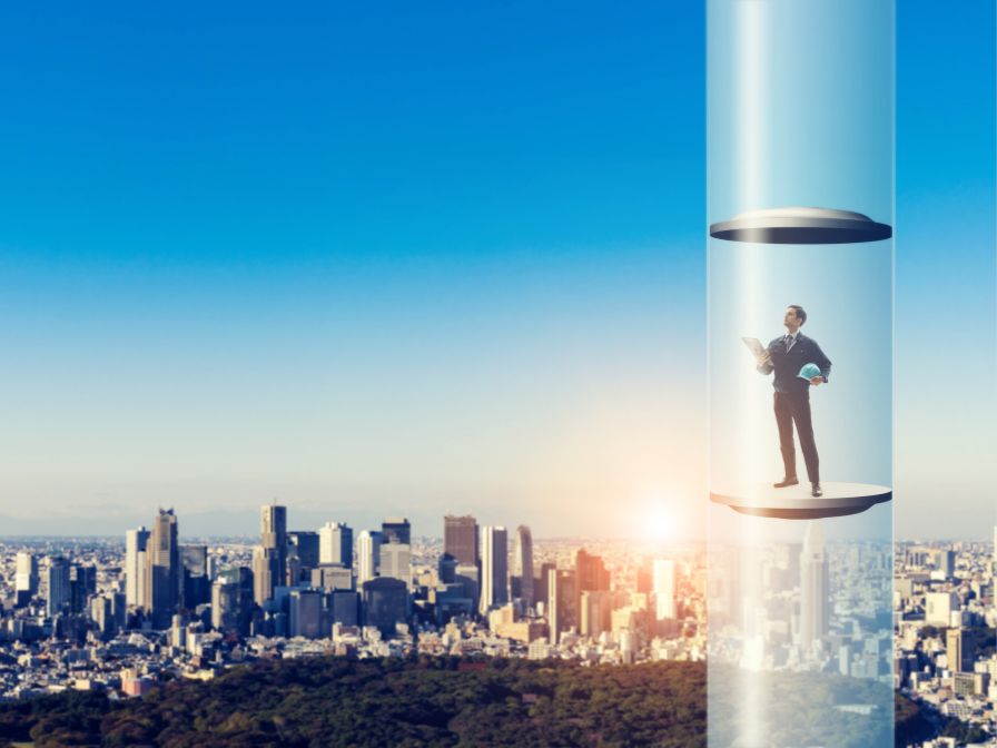 Businessman in elevator rising above the city