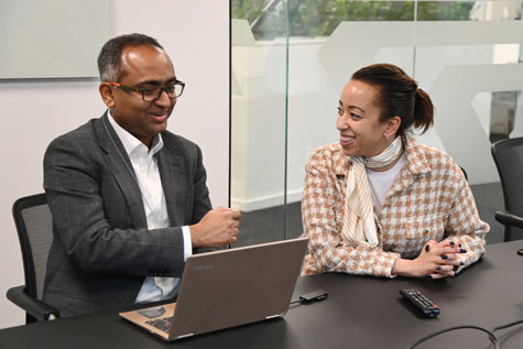 Man and woman sitting at desk smiling