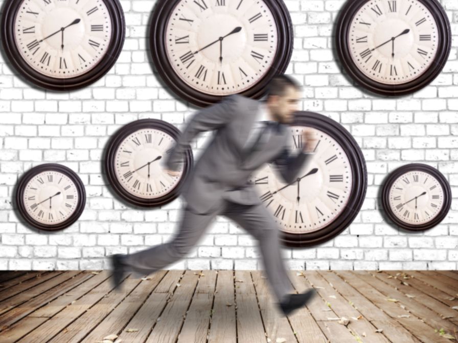 Blurry businessman running in front of multiple clocks