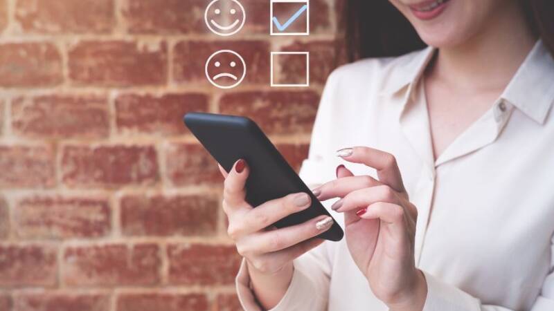 Woman on smartphone rating a positive customer experience