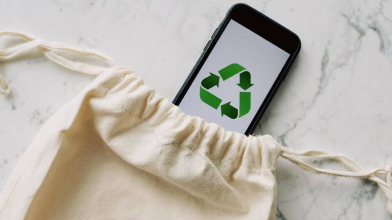 Cell phone with recycle symbol in sustainable pouch