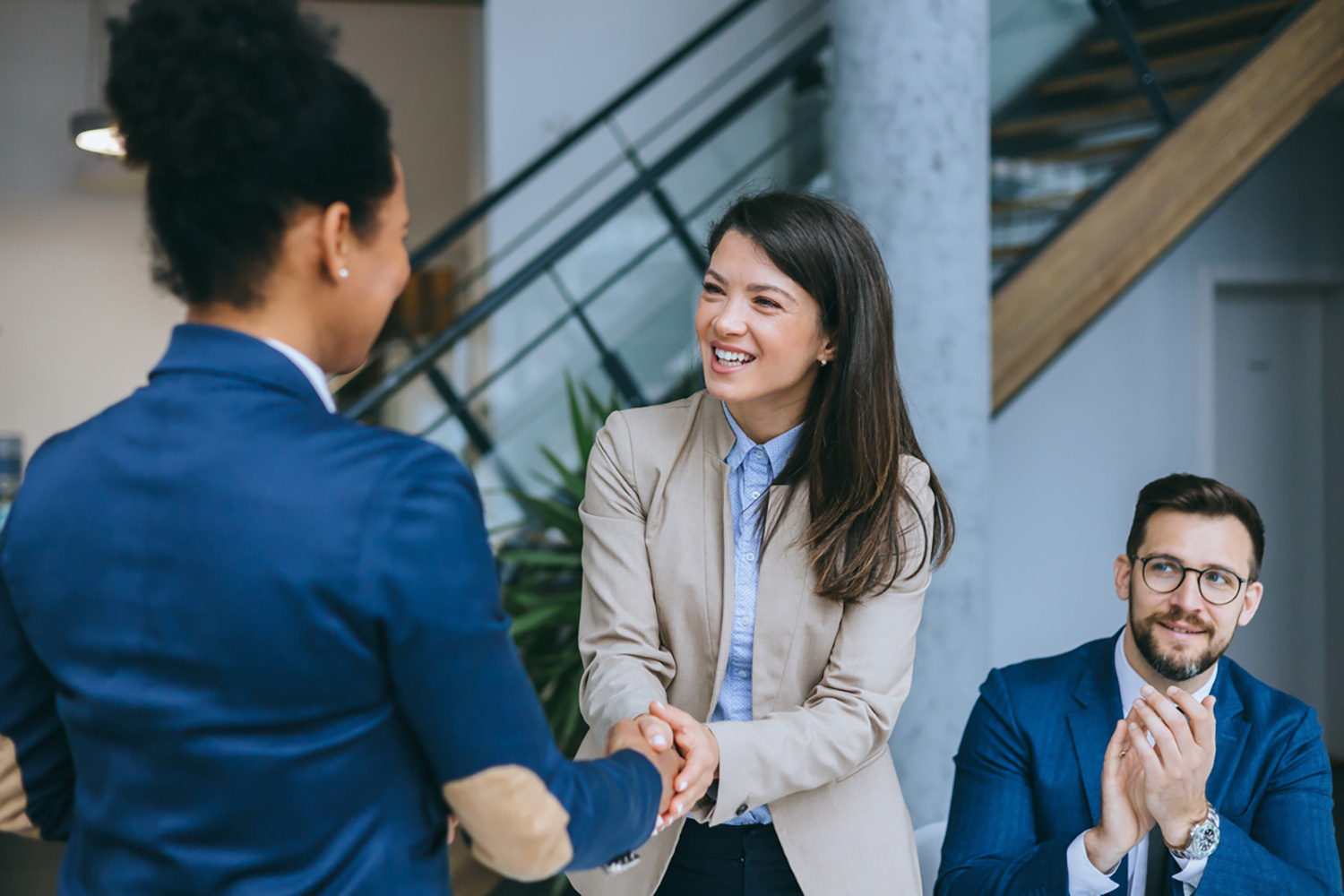 Happy employees shaking hands