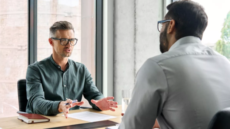 Banker talking to man at desk